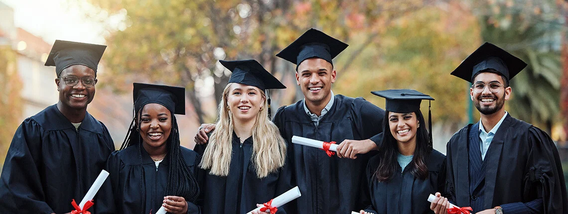 Groupe de diplômés levant leur diplôme en signe de réussite