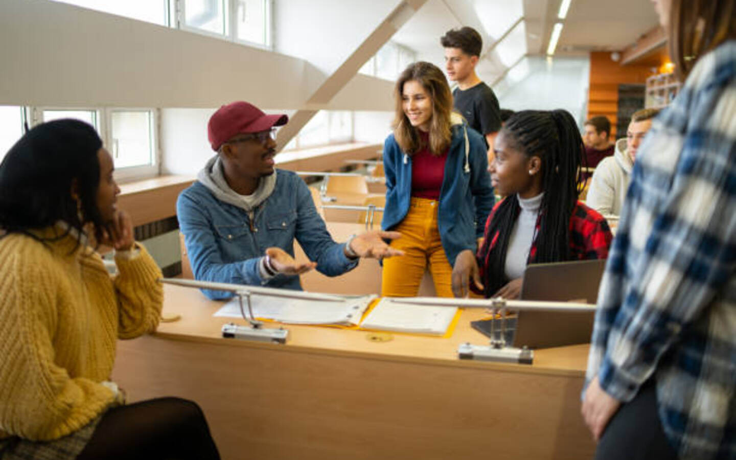 Groupe d'étudiants échangeant autour d'une table à la bibliothèque